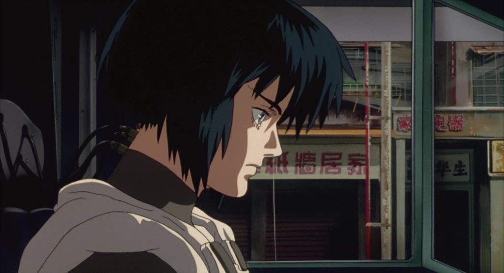 Figure 7. Screencap: Major Motoko Kusanagi communicating non-verbally with her team. Her body is emptied from her Ghost as she is wired to the vehicle via her neck. Oshii, Mamoru. Ghost in the Shell. Manga Entertainment, 1998, DVD.